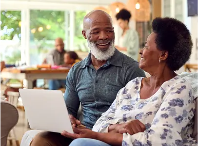Seniors cozy on the couch signing up for Medicare Advantage