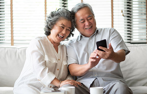 Senior couple using phone to sign up for medicare advantage